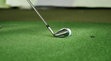a golf ball and a golf club on a putting green